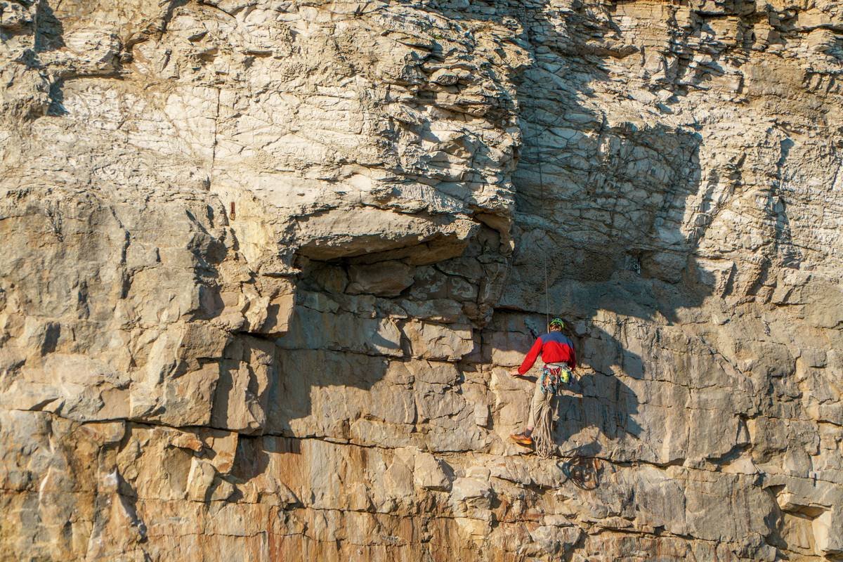 Before/after photos of a cleaned pitch on El Capitan showing removed pitons and new bolt placement