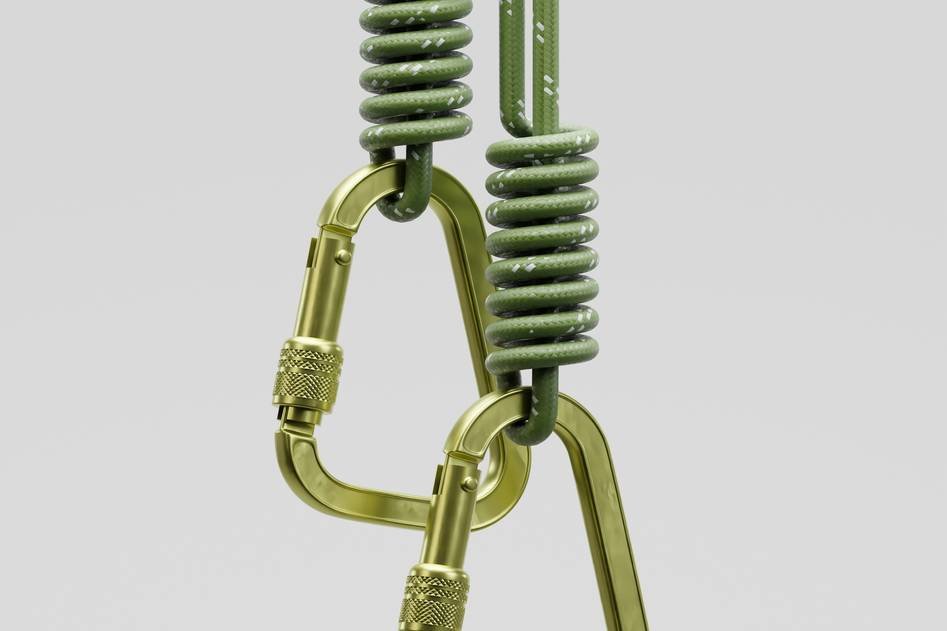 Climber securing a climbing anchor on a rocky cliff at sunrise