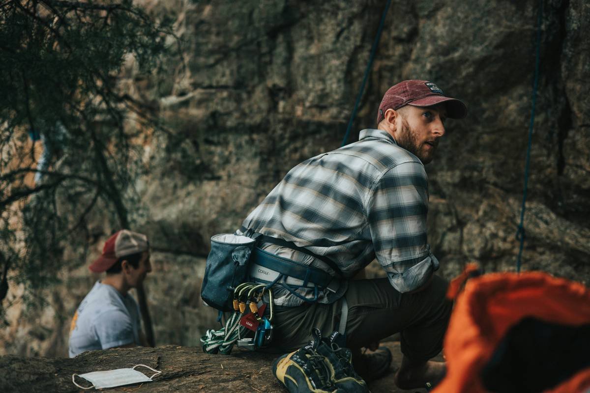 Climber backing up corroded bolts with cam and redirected belay on El Capitan slab