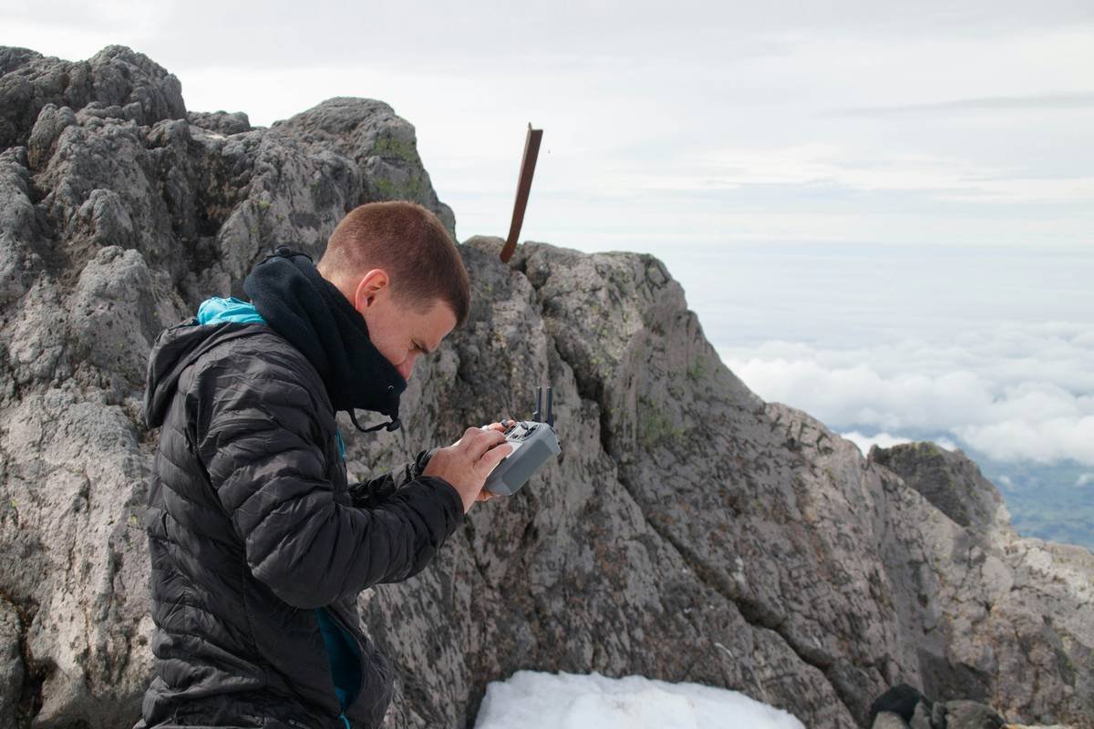 Close-up of climber using rock climbing anchors book at base of cliff for reference